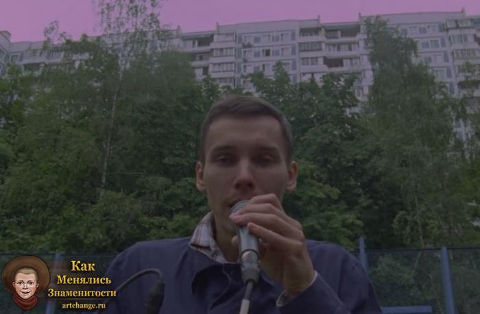 Антоха МС в клипе поет в микрофон на фоне многоэтажек