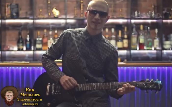 Вадяра Блюз с гитарой в клипе под названием как дела, сидит в баре